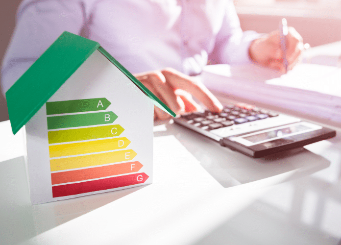calculatrice à côté d'une maison miniature avec un barème dpe