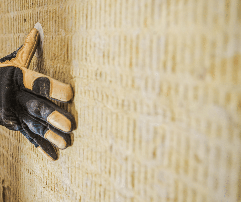 personne tenant un mur de laine de roche