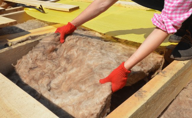 homme qui réalise une isolation thermique par l'extérieur (ITE)