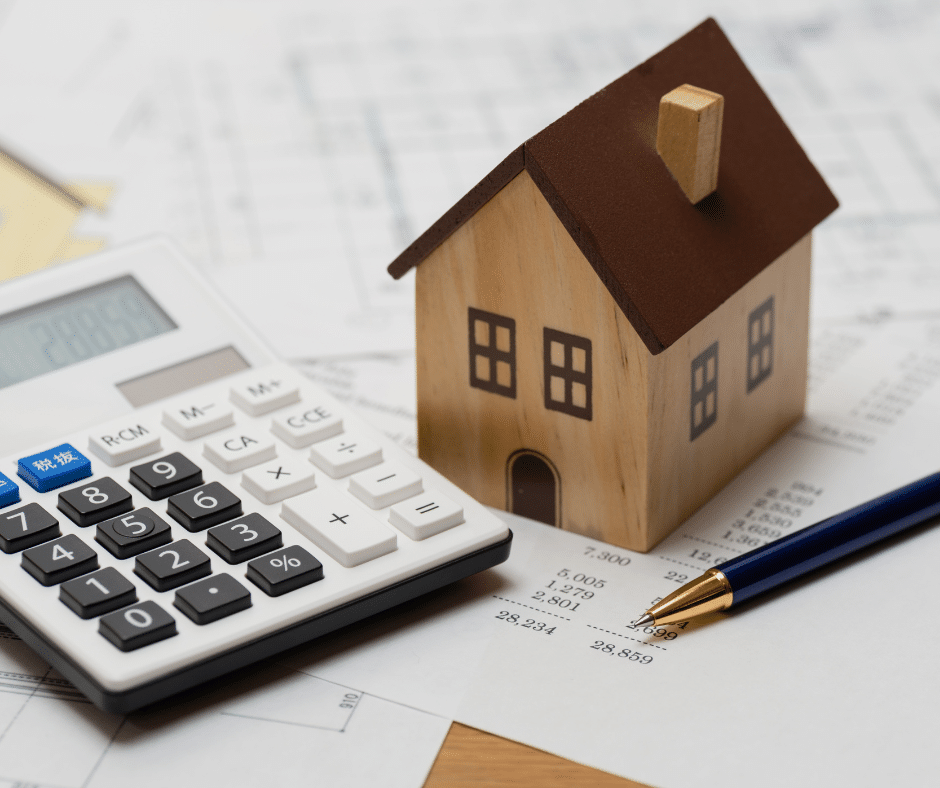 maison miniature à côté d'une calculatrice