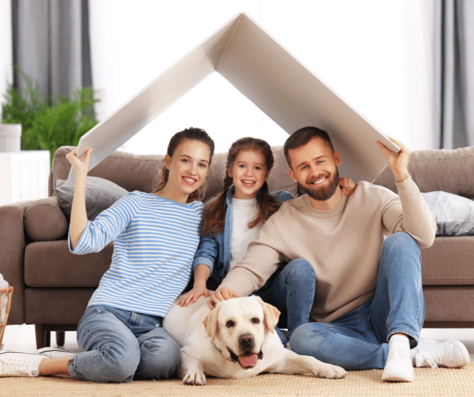 famille qui tient un carton en forme de toit de maison